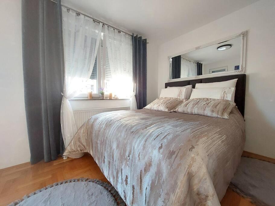 Un dormitorio con una cama grande y una ventana en Royal Place Apartment - East Sarajevo, en Lukavica