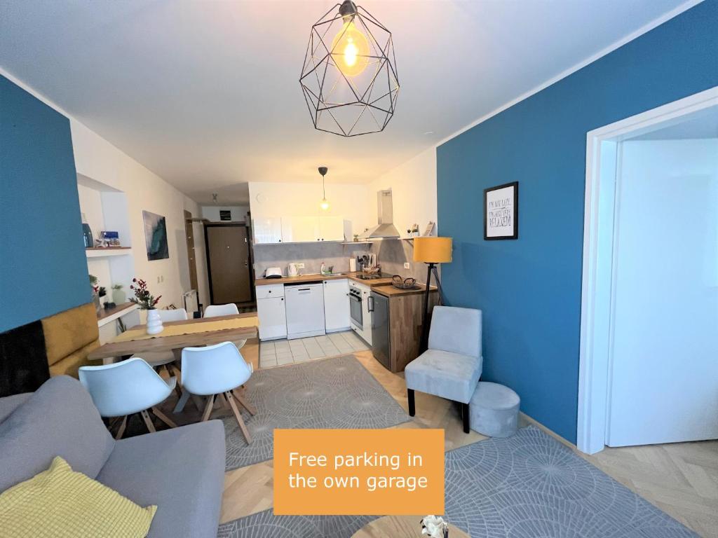 a kitchen and a living room with a blue wall at Cosy apartment - Zagreb Downtown with own parking spot in the garage in Zagreb