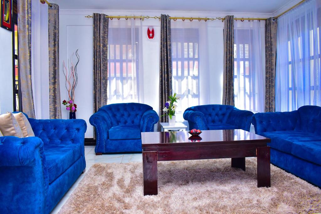 a living room with blue couches and a coffee table at Rozy Penthouse in Kisumu