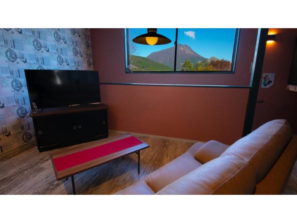 a living room with a couch and a flat screen tv at Innterhill Tsubasa Yufuin - Vacation STAY 94236v in Yufuin