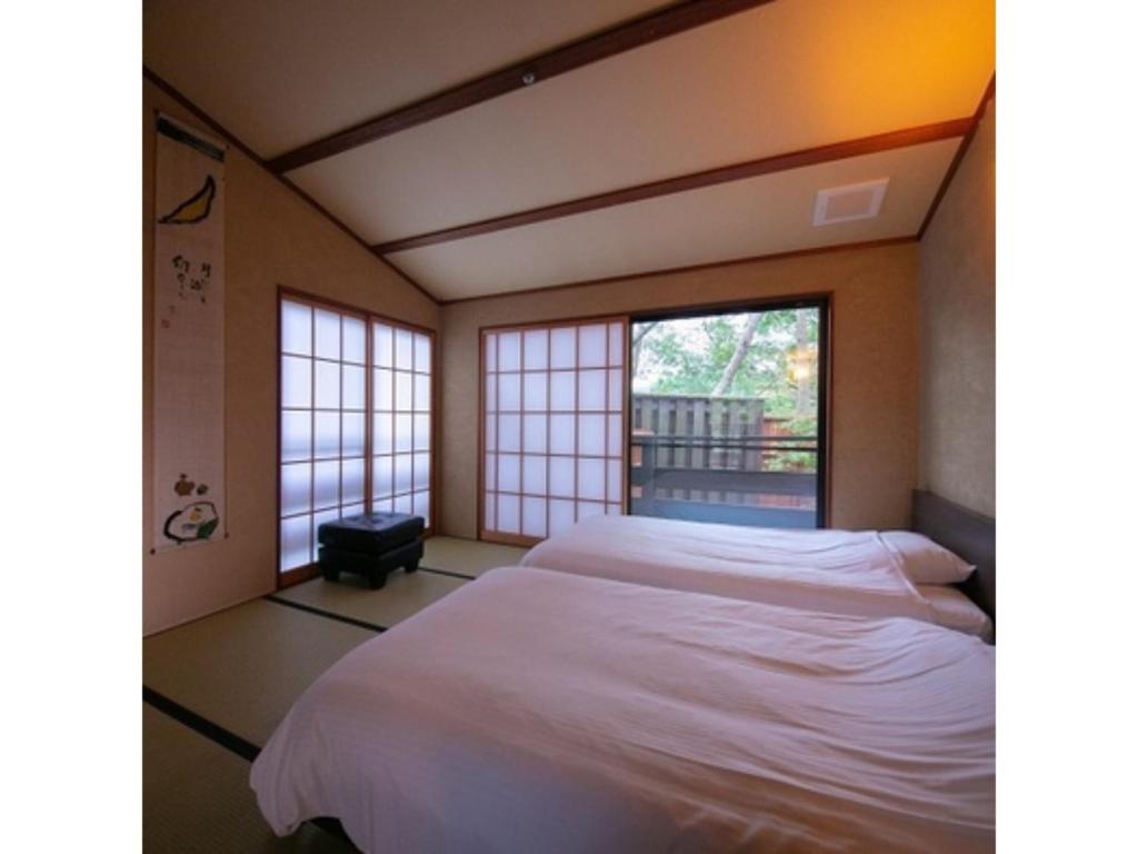 a bedroom with a large bed and a window at Innterhill Tsubasa Yufuin - Vacation STAY 94239v in Yufuin