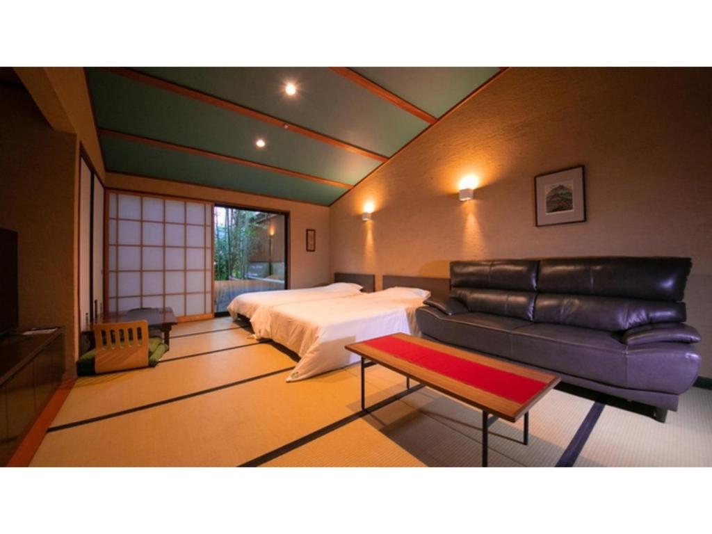 a bedroom with a bed and a couch and a table at Innterhill Tsubasa Yufuin - Vacation STAY 94225v in Yufuin