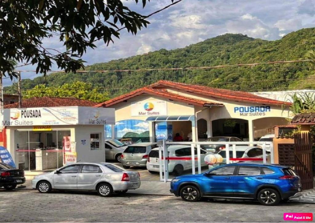two cars parked in front of a gas station at Pousada Mar Suites in Ubatuba