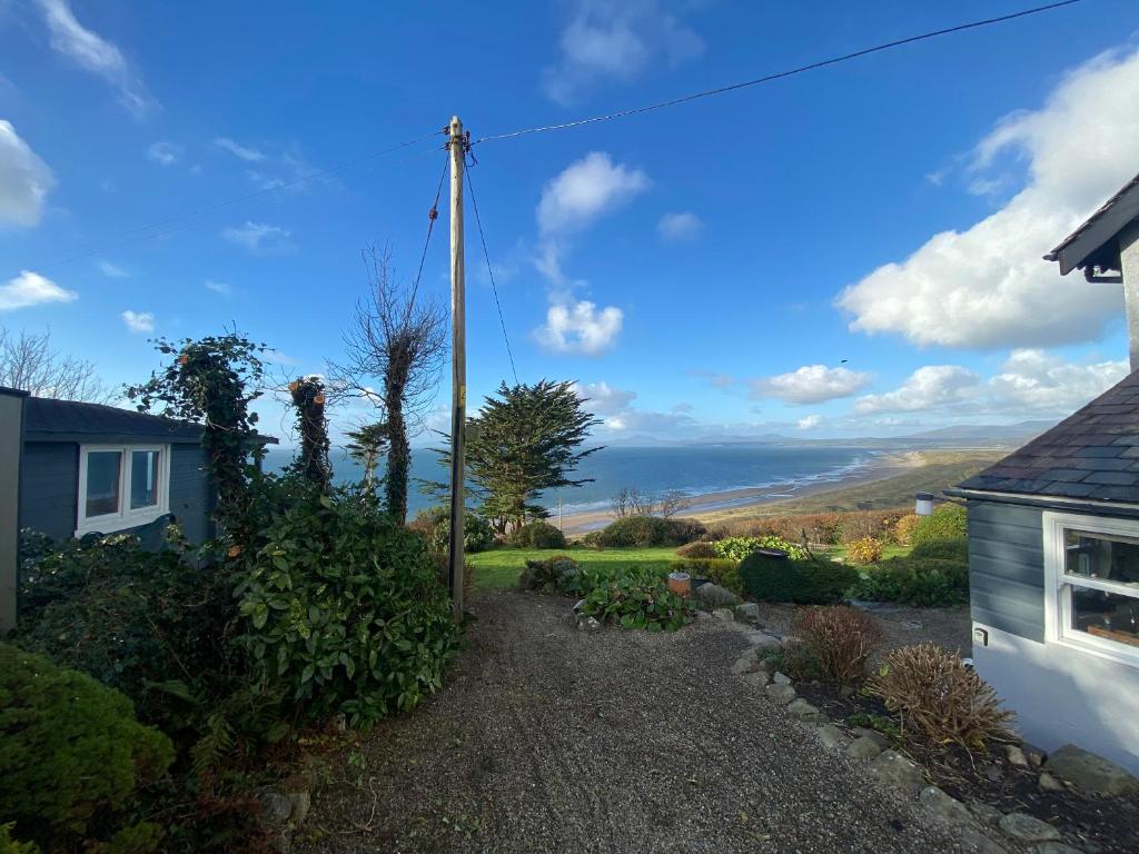 a view from the garden of a house with a pole at Sibrwd Y Mor in Harlech