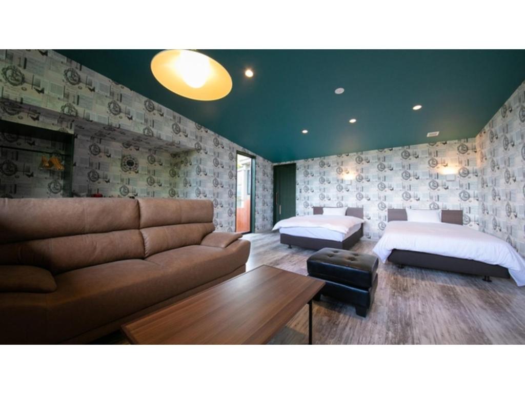 ein Wohnzimmer mit einem Sofa und 2 Betten in der Unterkunft Innterhill Tsubasa Yufuin - Vacation STAY 94222v in Yufu