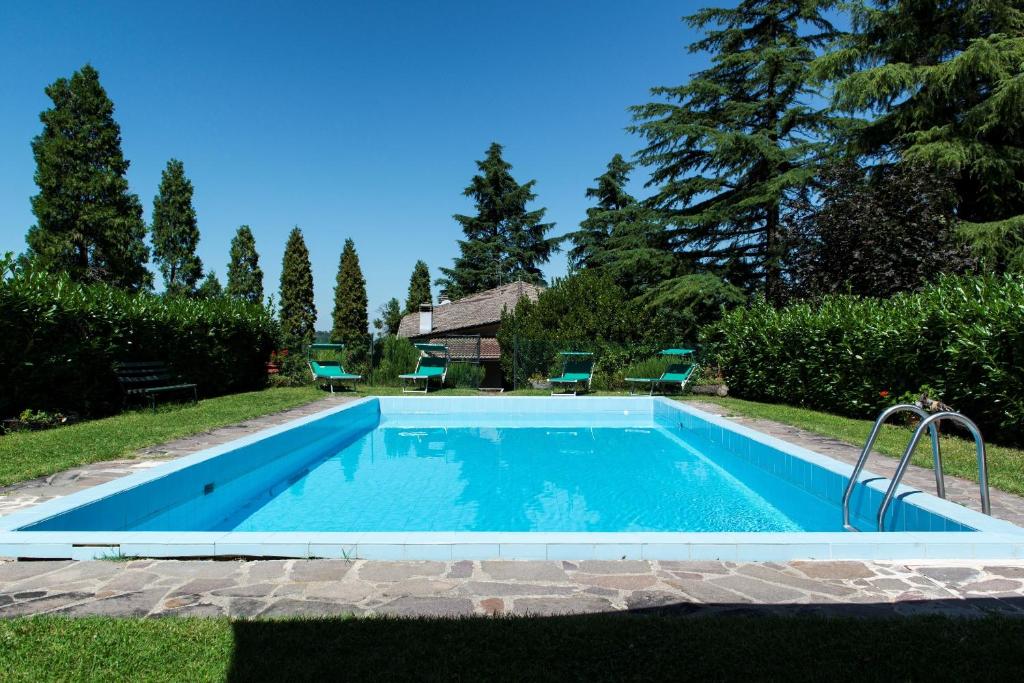 - une piscine dans une cour avec des chaises et des arbres dans l'établissement La Secchia Rapita, à Zappolino