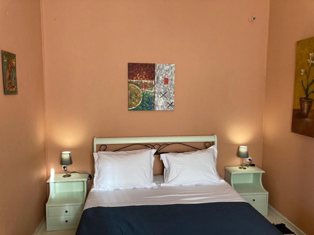 a bedroom with a bed with two nightstands and two lamps at Sergios Village House in Chania