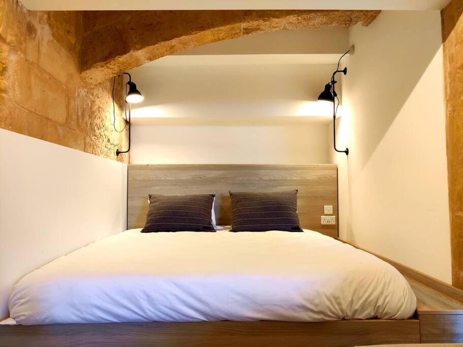 a bedroom with a large white bed with two pillows at Ripple 23 Savynomad Harbour Residences in Valletta