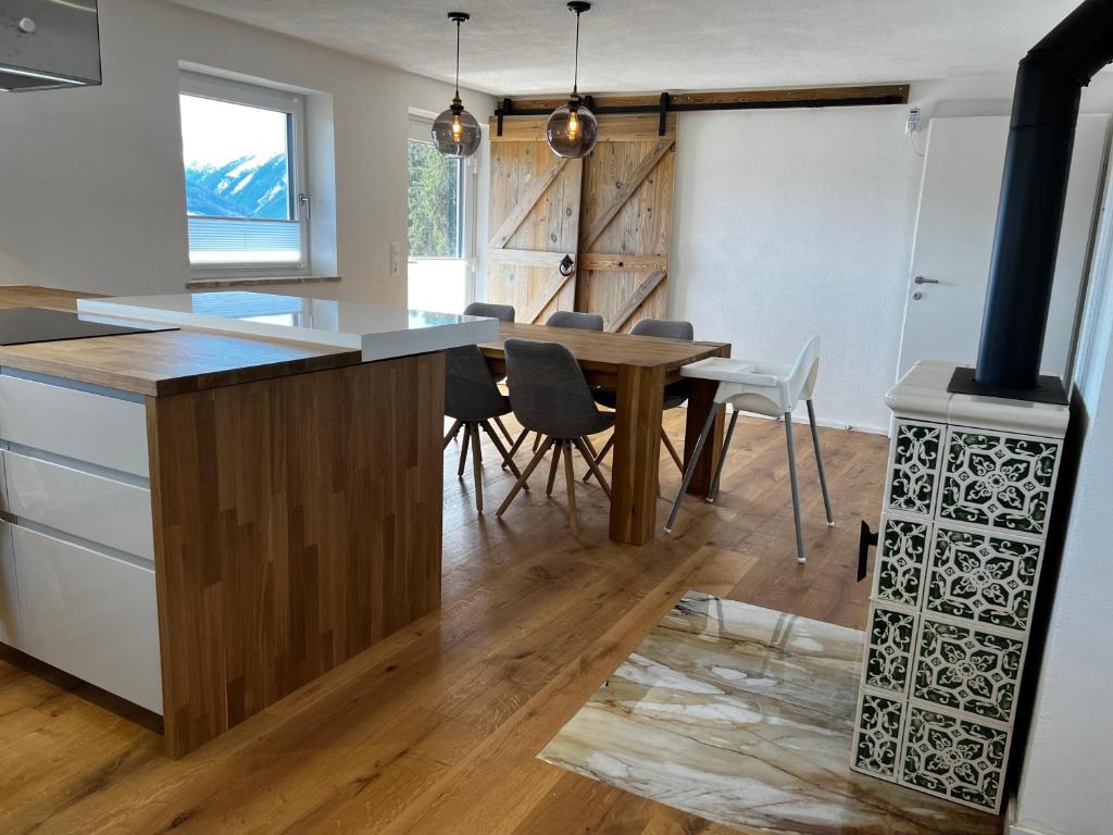 a kitchen with a wooden table and a stove at Haus Bergfeld with the view over Dachstein in Ramsau am Dachstein