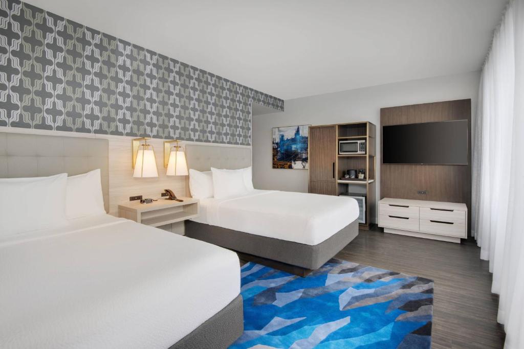 a hotel room with two beds and a tv at Courtyard by Marriott Atlanta Downtown in Atlanta