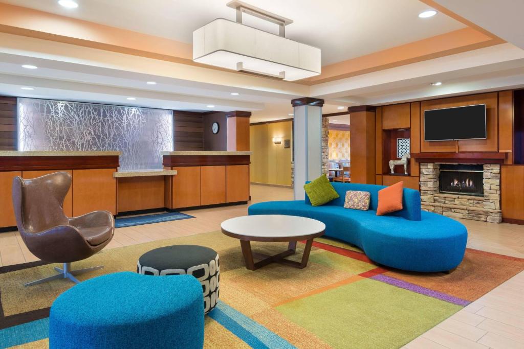 a living room with a blue couch and a chair at Fairfield Inn & Suites by Marriott Springdale in Springdale