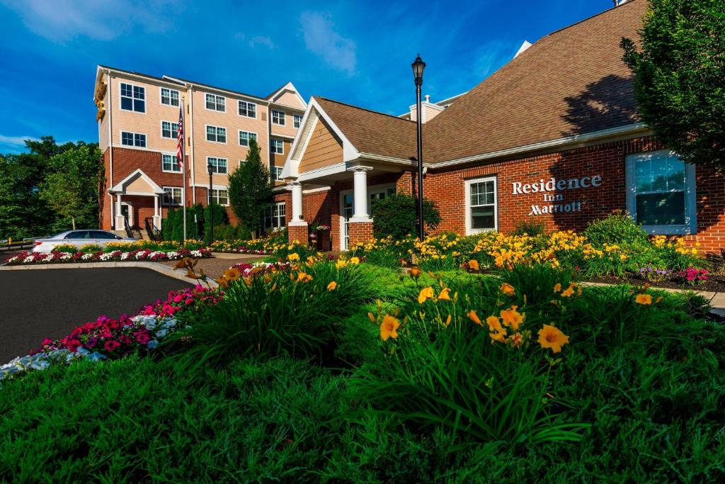 a hotel with flowers in front of a building at Residence Inn Worcester in Worcester