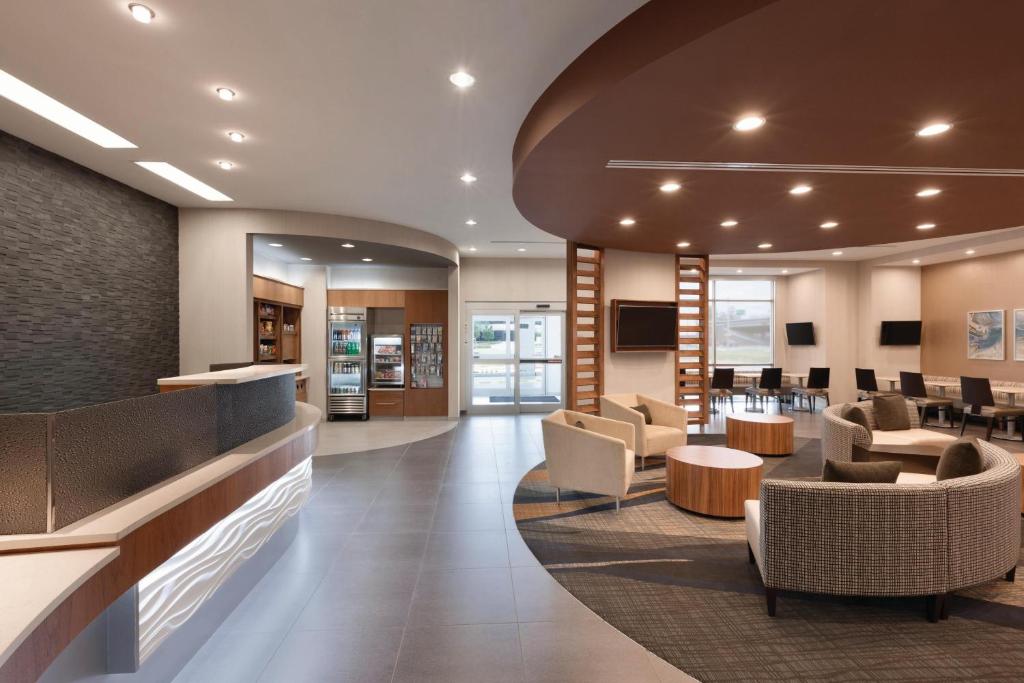 a lobby with a waiting area with chairs and tables at SpringHill Suites by Marriott Houston Northwest in Houston