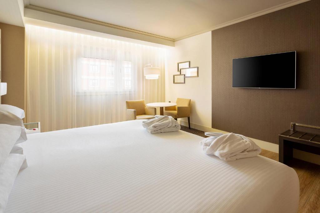 A bed or beds in a room at Madrid Marriott Auditorium Hotel & Conference Center