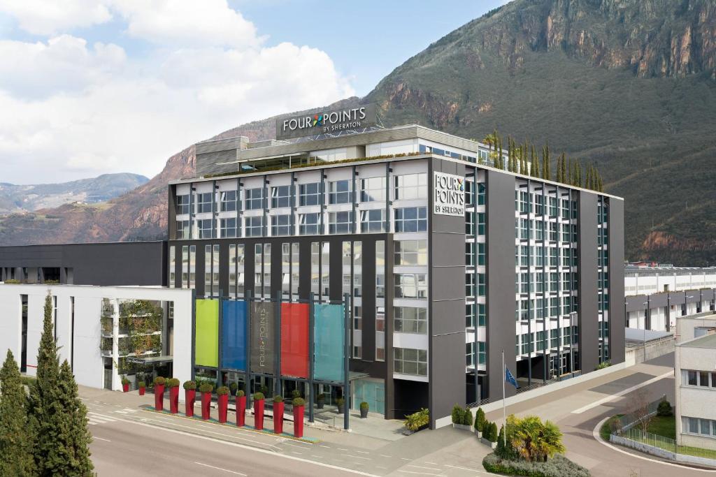 een weergave van een gebouw met een berg op de achtergrond bij Four Points Sheraton Bolzano Bozen in Bolzano