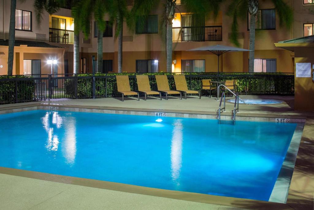 a large blue swimming pool in a hotel at Courtyard by Marriott Daytona Beach Speedway/Airport in Daytona Beach