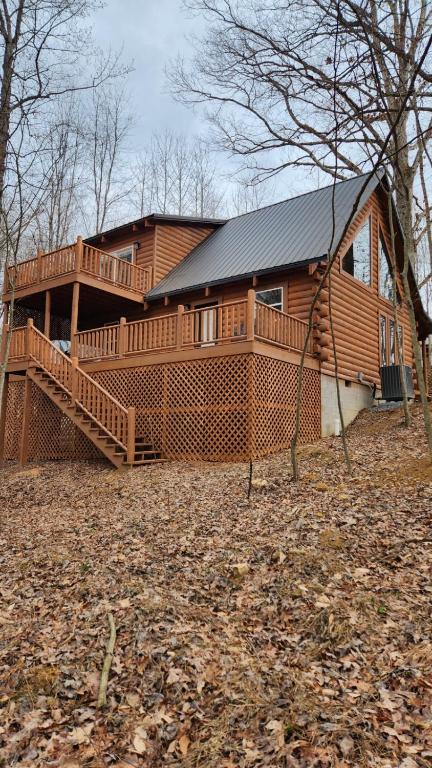 a large wooden house with a large deck at Flying High Luxury Cabin in Campbellsville