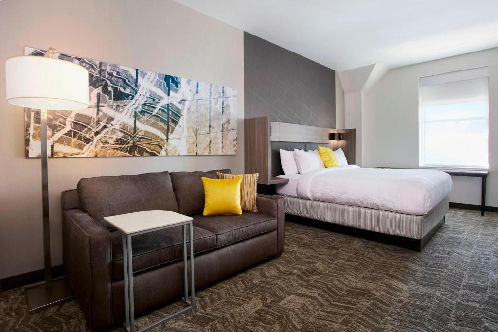 um quarto com uma cama e um sofá e uma cama e uma cama em SpringHill Suites by Marriott Milwaukee Downtown em Milwaukee
