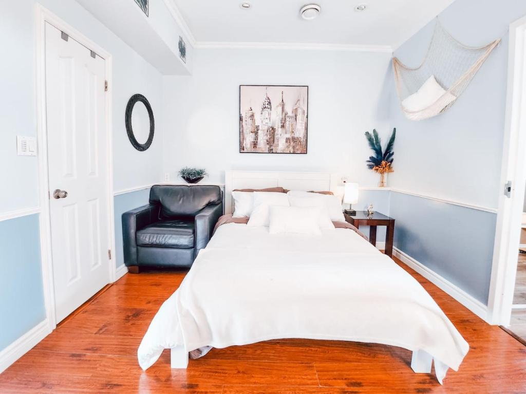 sypialnia z dużym białym łóżkiem i czarnym krzesłem w obiekcie Hotel-Like stay! w mieście Edmonton