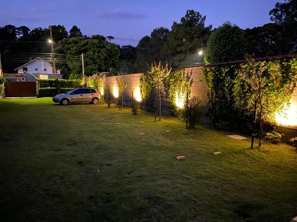 a car parked in a yard at night with lights at Chamonix Chales - OAK Plaza in Monte Verde
