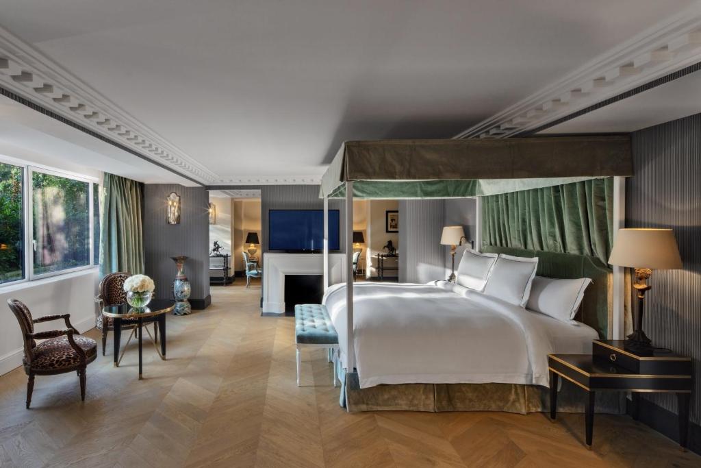 a bedroom with a large bed and a living room at Hôtel de Berri Champs-Élysées, a Luxury Collection Hotel in Paris