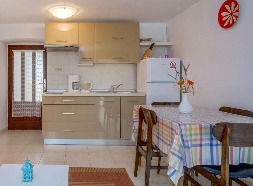 a kitchen with a table and a white refrigerator at Guesthouse Stivan (920) in Štivan