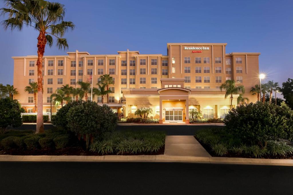 a large building with palm trees in front of it at Residence Inn Orlando Lake Mary in Lake Mary