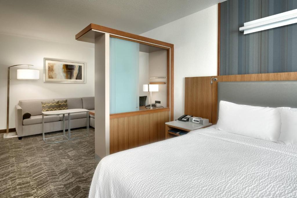 レックスバーグにあるSpringHill Suites by Marriott Rexburgのベッドとリビングルームが備わるホテルルームです。