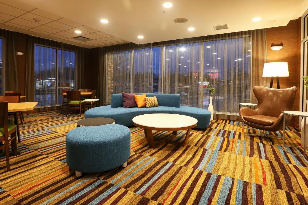 a living room with a couch and a table and chairs at Fairfield Inn & Suites by Marriott Madison Verona in Verona