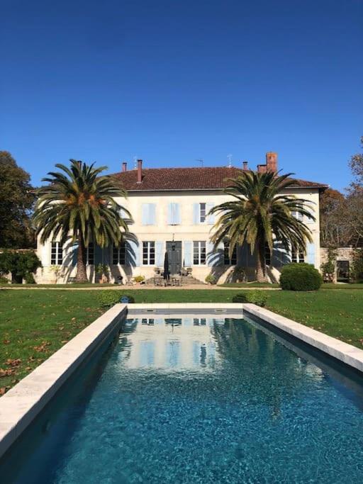 une grande piscine devant une maison dans l'établissement Les Charmilles, à Sames