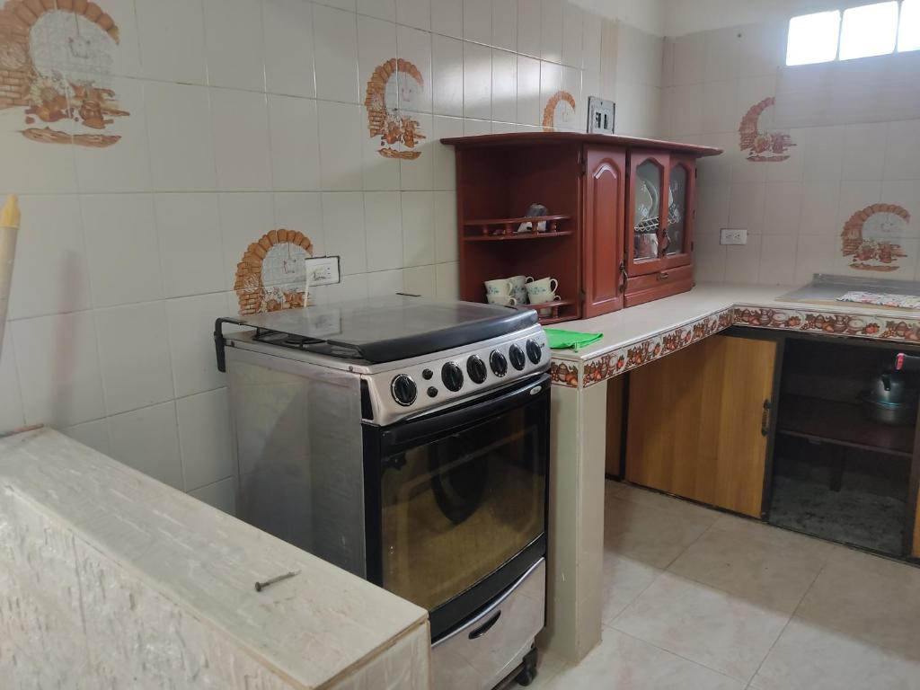 a kitchen with a stove and a counter top at Habitación en apartahotel Sarita Salento in Salento