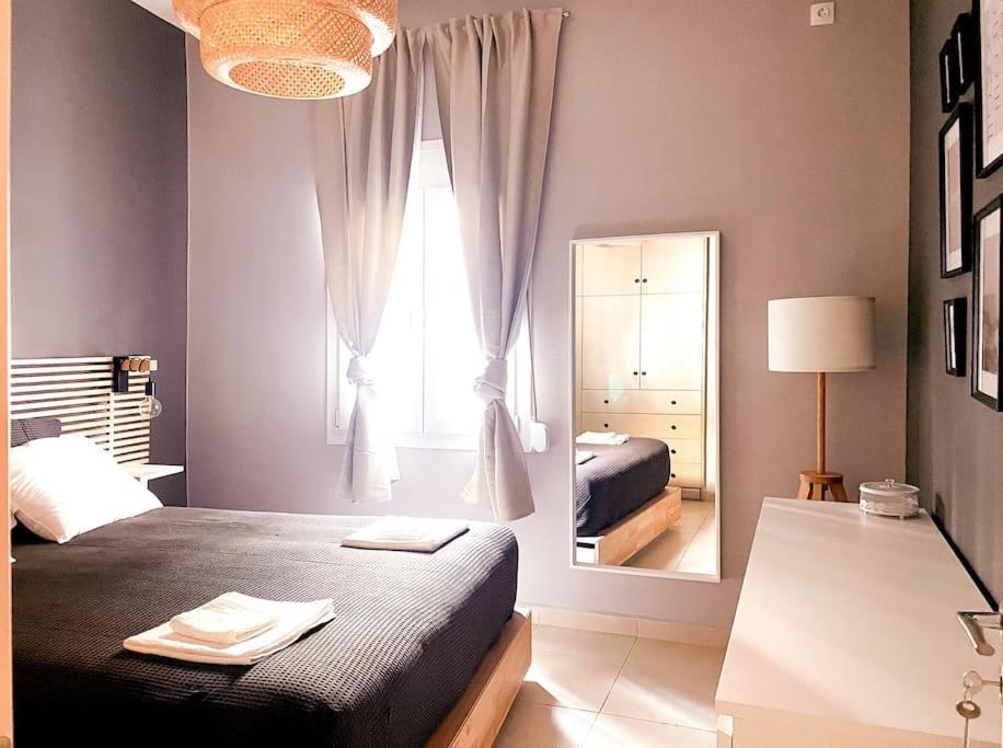 a bedroom with a bed and a large mirror at Cozy Apartment in Korydallos in Piraeus
