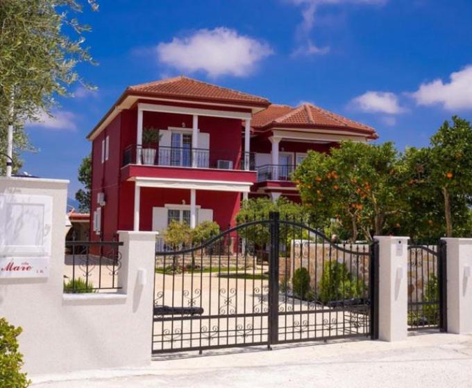une maison rouge avec une porte devant elle dans l'établissement Villa Mare Ammoudia, à Ammoudia