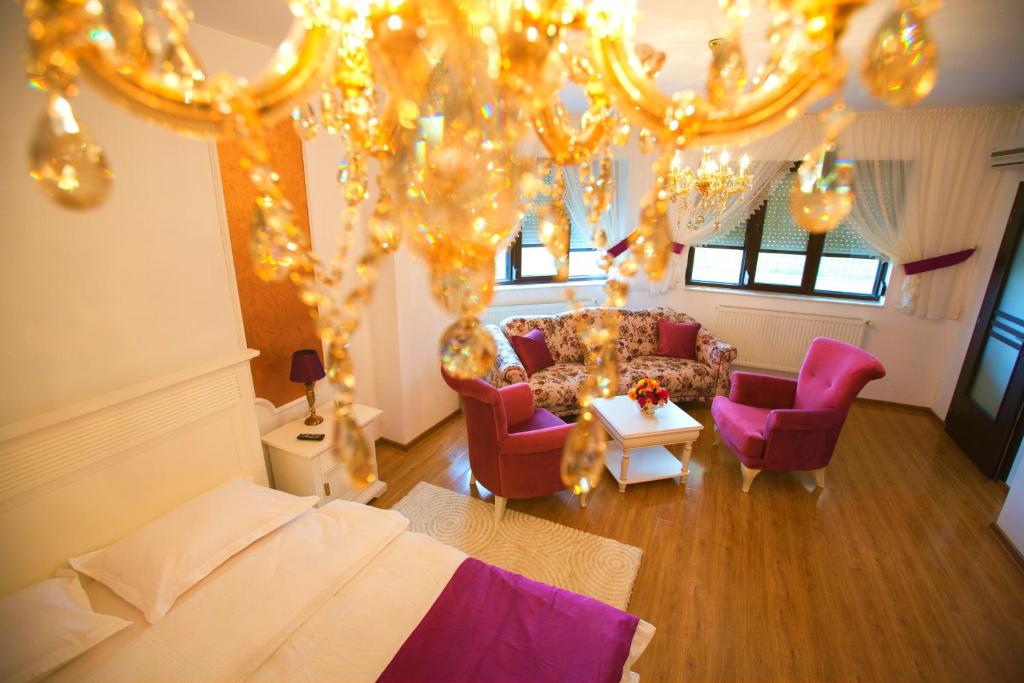 ガラツィにあるNoblesse Suiteのリビングルーム(ベッド、椅子、照明付)