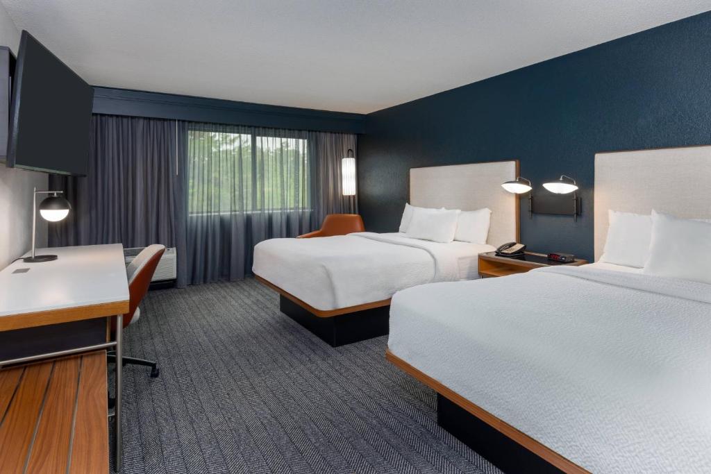 um quarto de hotel com duas camas e uma secretária em Courtyard Tallahassee North/I-10 Capital Circle em Tallahassee