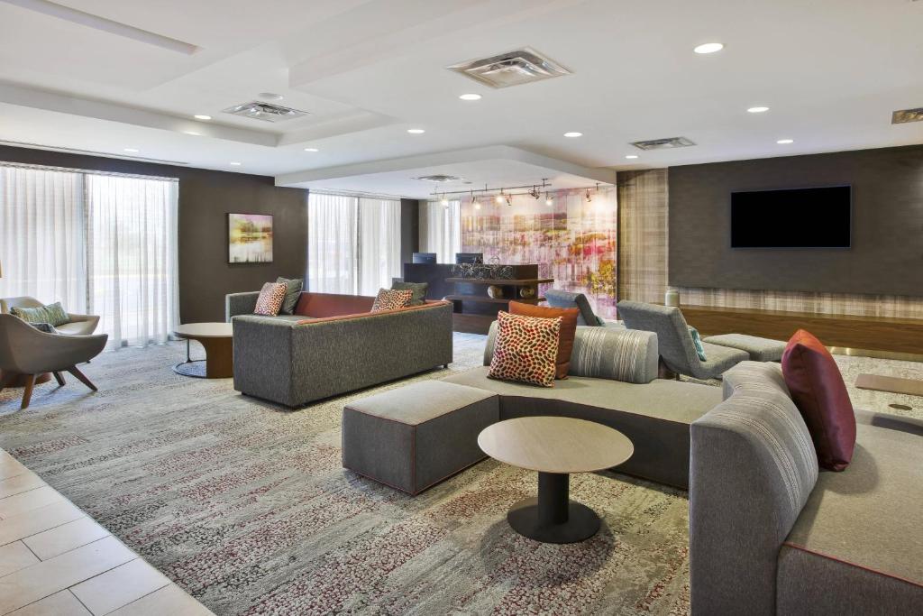 a lobby with couches and chairs and a television at Courtyard by Marriott Somerset in Somerset