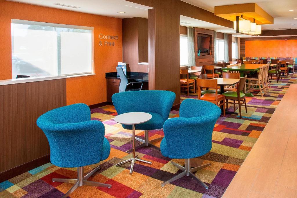 a waiting area with blue chairs and tables in a restaurant at Fairfield Inn & Suites South Bend Mishawaka in South Bend