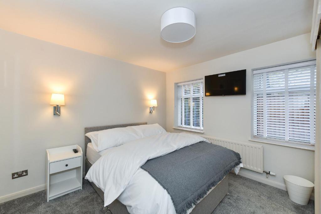 a bedroom with a large bed and two windows at Rooms at Rolleston in Rolleston