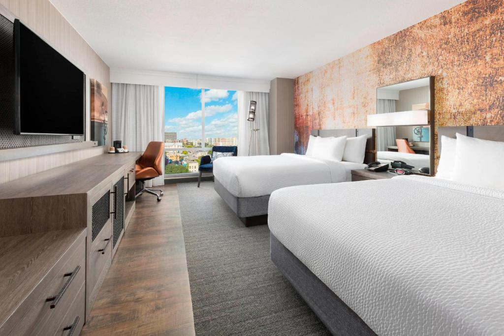 奧斯汀的住宿－奧斯丁市區/會展中心萬怡酒店，酒店客房设有两张床和一台平面电视。