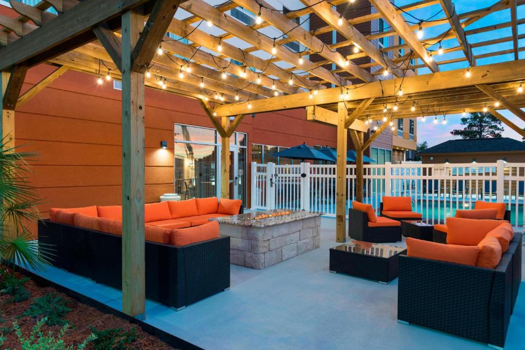 a patio with orange chairs and a wooden pergola at Fairfield Inn & Suites by Marriott West Monroe in West Monroe