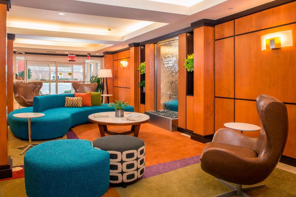 フレデリックにあるFairfield Inn & Suites by Marriott Frederickのロビー(青いソファ、テーブル、椅子付)