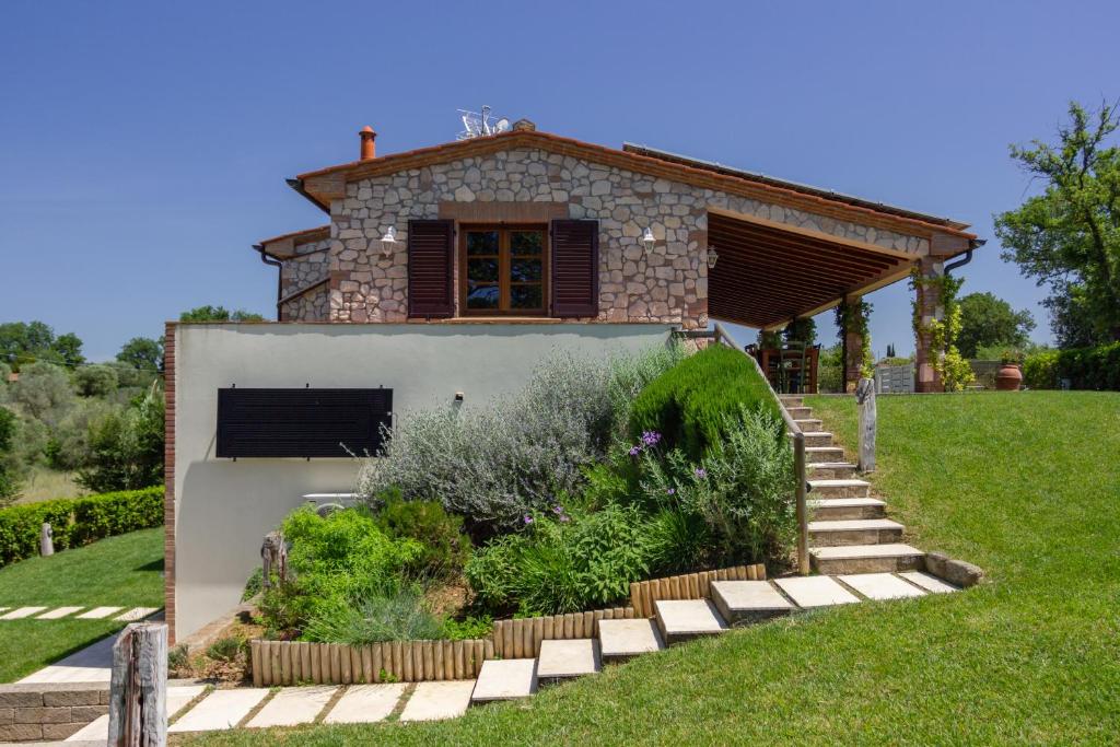 ein Haus mit einer Steintreppe, die zu einem Gebäude führt in der Unterkunft CASE&COLLINE Villa Eliso in Bibbona