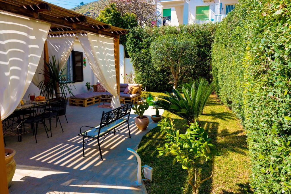 een tuin met een bank en een heg bij Villa Cinzia in Mondello