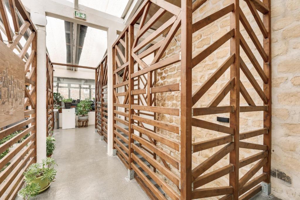 a wall of wooden panels in a hallway with plants at L&#39;Oasis Montparnasse in Paris