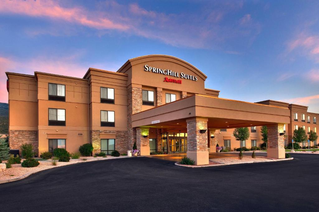 a spanish suite hotel with a parking lot at SpringHill Suites by Marriott Cedar City in Cedar City