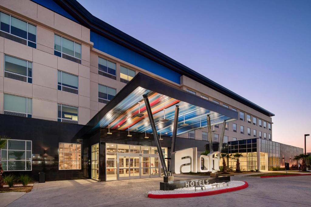 a building with a hotel sign in front of it at Aloft Katy Mills in Katy