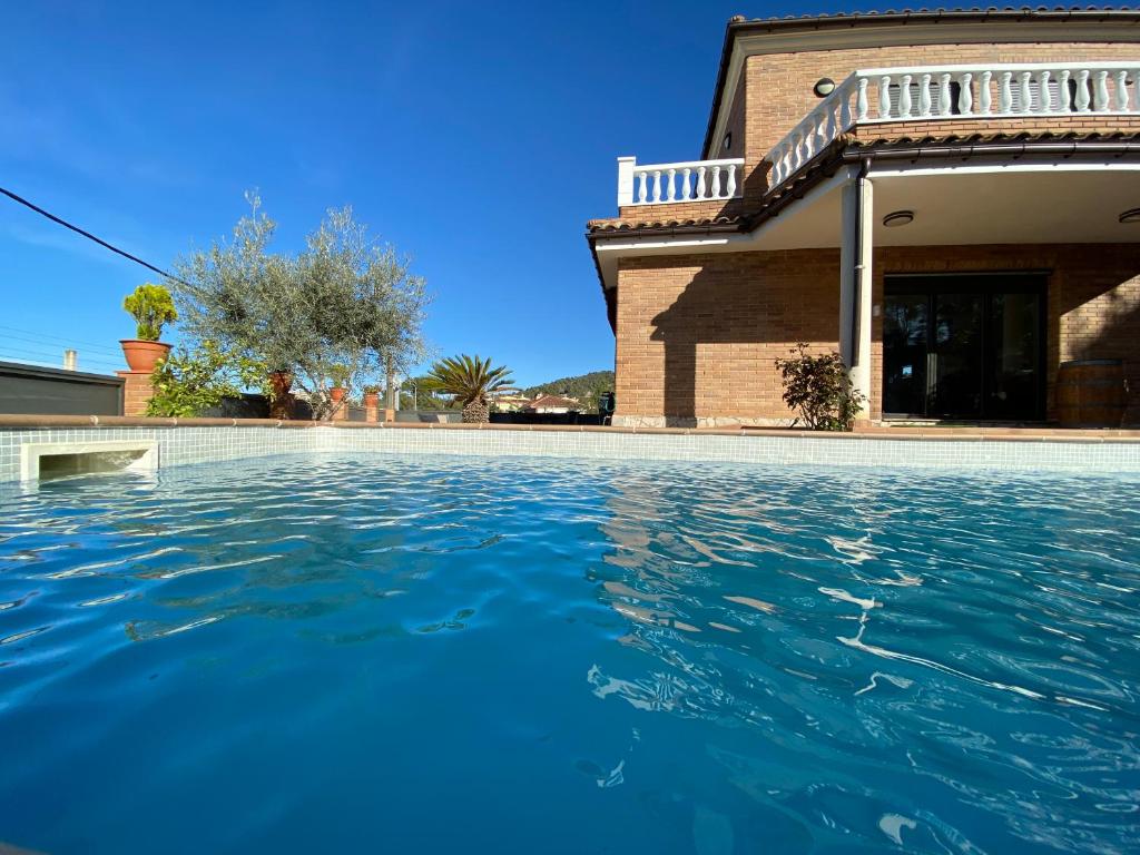 una piscina frente a una casa en Villa Belephant Sitges, en Canyelles