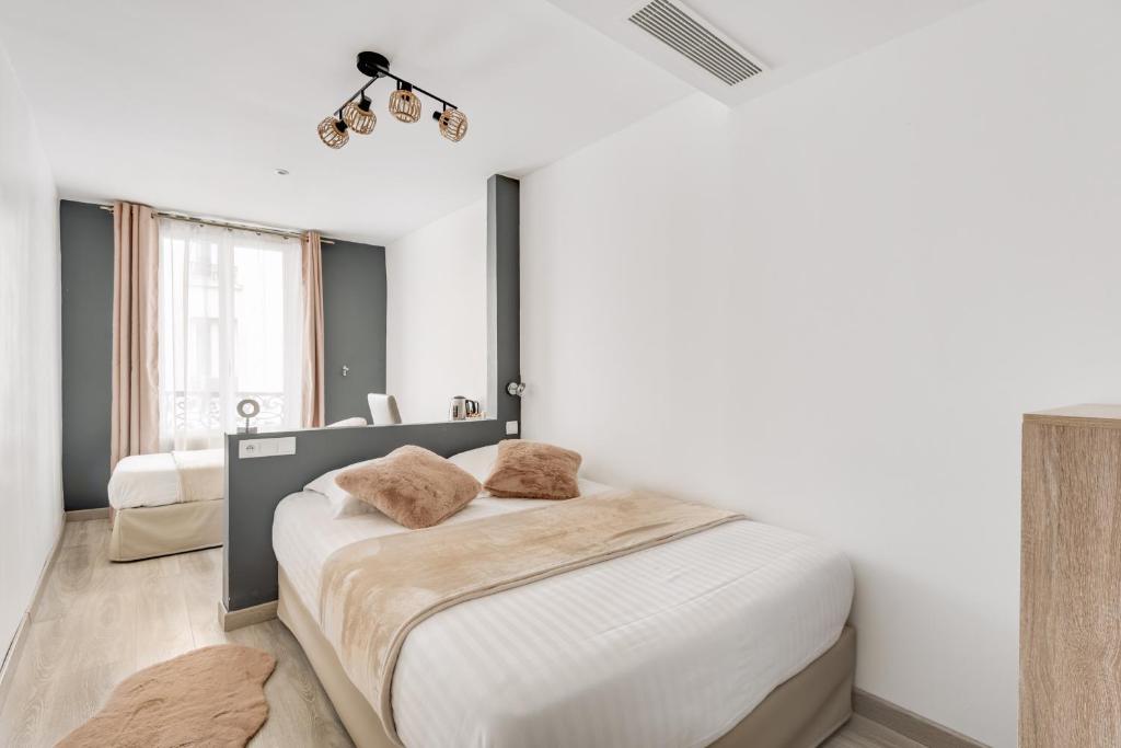 a bedroom with a large bed and a window at L&#39;Oasis Montparnasse in Paris
