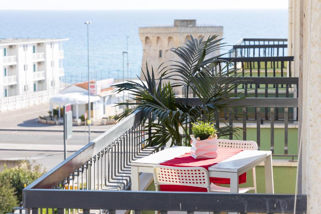 a table with a potted plant on top of a balcony at La Casa di Annale' in Gallipoli