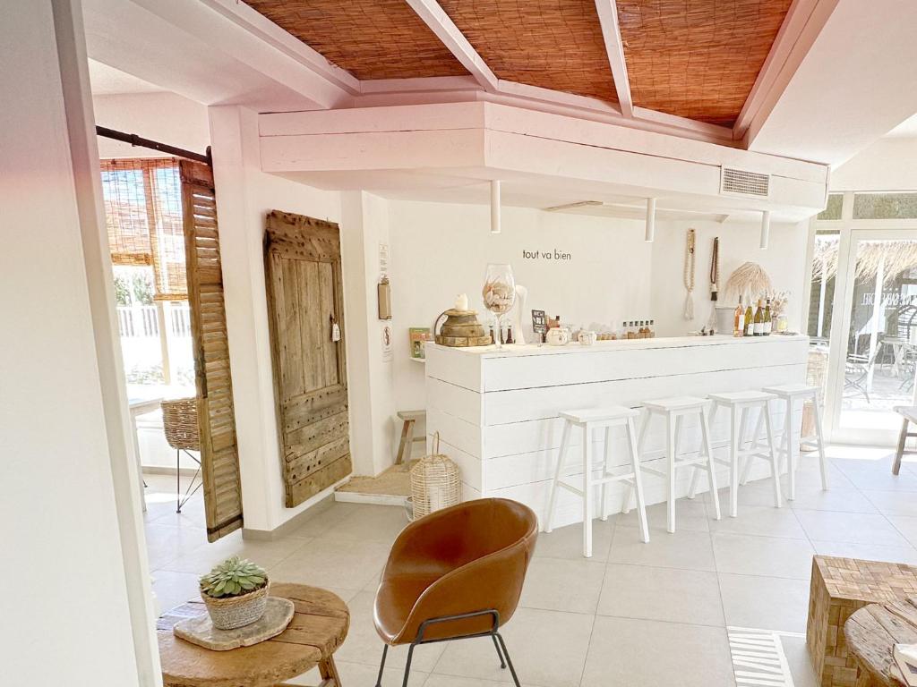 a kitchen with a bar and some chairs and tables at Blanc Sable Hôtel in Golfe-Juan